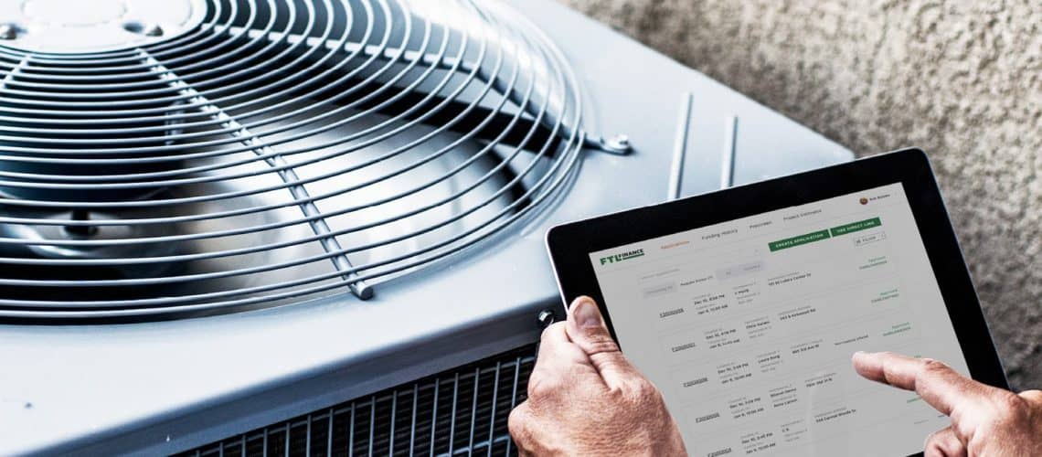 Man standing infront of an A/C unit holding a tablet